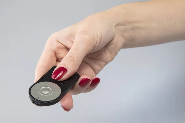 Black remote controler in the hand of a young girl — Stock Photo, Image