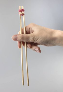 Eğitim bambu çubuk suşi için tutan kadın