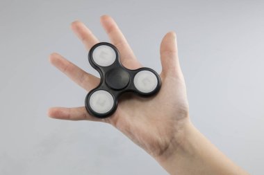 Çocuk bir siyah plastik spinner tutuyor