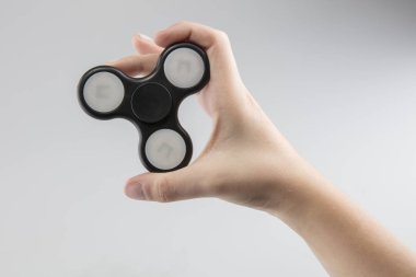 Çocuk bir siyah plastik spinner tutuyor