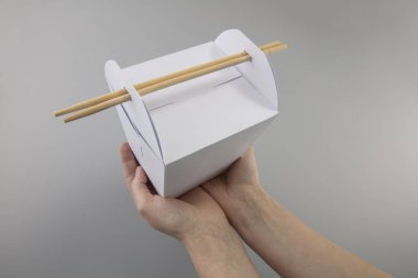 bir kız için yemek Wok elinde çubuk şeklinde kulplu mock-up kutular