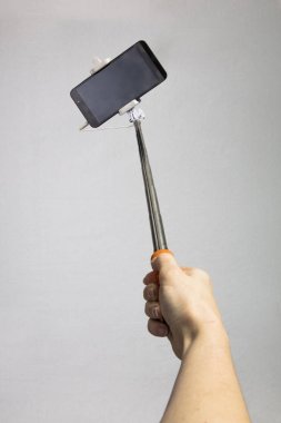 selfie-monopod ile kızın elinde siyah cep telefonu