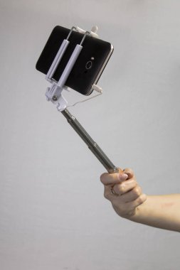 selfie-monopod ile kızın elinde siyah cep telefonu