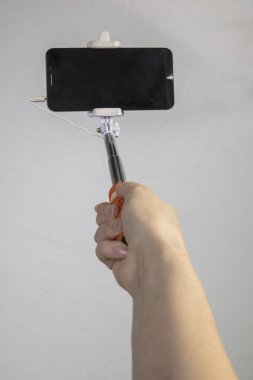 selfie-monopod ile kızın elinde siyah cep telefonu