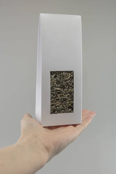mockup box for tea in the hands of a woman