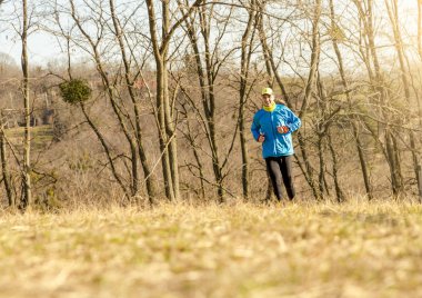 Doğada koşan atletik genç adam. Sağlıklı yaşam tarzı