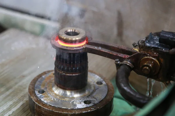 Proceso de calentamiento y enfriamiento de metal. Endurecimiento de la pieza de acero en producción . —  Fotos de Stock