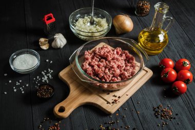 Çiğ et ve malzemeler siyah ahşap bir masada. Ev yemeği..