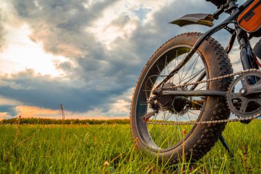 Elektrikli motoru olan kalın tekerlekleri olan bir bisiklet. Güzel gökyüzüne karşı şişko motosikleti.
