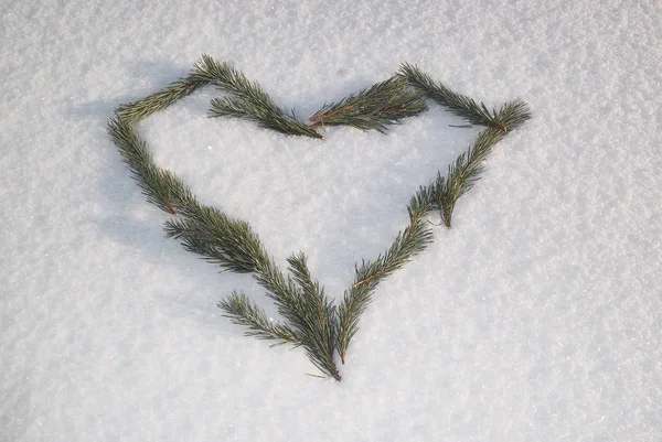 Green love symbol on the snow.