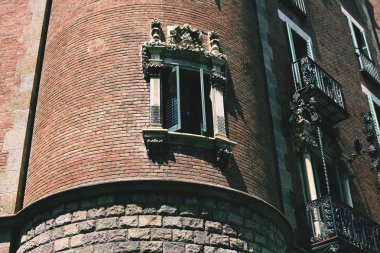 Eski bir binanın ön cephesinde güzel desenli bir pencere.