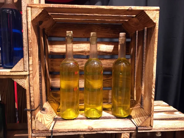 Old Bottles of Wine in a Wooden Wine Box. Vintage wooden wine crate. Bottles of colored drinks in gift wooden box. Bottles in a wooden box. Home winemaking. Wine cabinet made of drawers