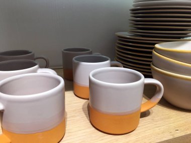 Ahşap arka planda çok renkli kepler ve kaseler. Çömlekçi. Tasarımcı seramik yemekleri. Seramik masa takımı üst görünümü. Modern, boş, derin kaseler. Ev hanımı. Seramik tablo takımı