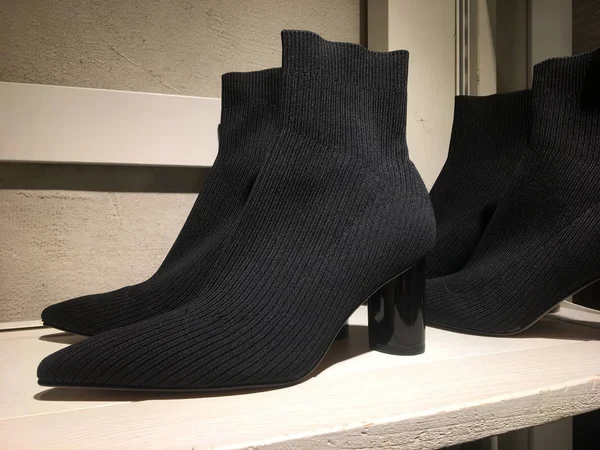 Black sock woven heel ankle boots for display to sell on shoes store. Mass market shop. Close View Of Fashion Casual Female shoes. Sale of modern women\'s shoes. Ladies High Heel Pointed Socks Boots