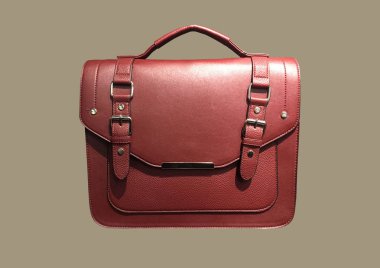 Red Leather Satchel Bag isolated on brown background. Cambridge Style Satchel Bag. Fashion handbag. Composition of clothes. Flat lay, top view, copy space. Accessories pattern