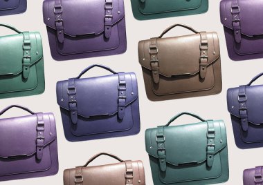 Multi-colored Leather Satchel Bag isolated on brown background. Cambridge Style Satchel Bag. Fashion handbag. Composition of clothes. Flat lay, top view, copy space. Accessories pattern