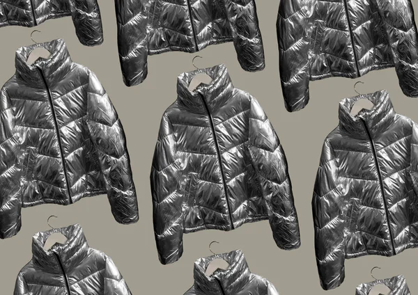 Metallic puffer down jacket on a hanger isolated on brown background. Composition of clothes. Flat lay, top view, copy space. Winter clothes pattern.  Padded coat Pattern