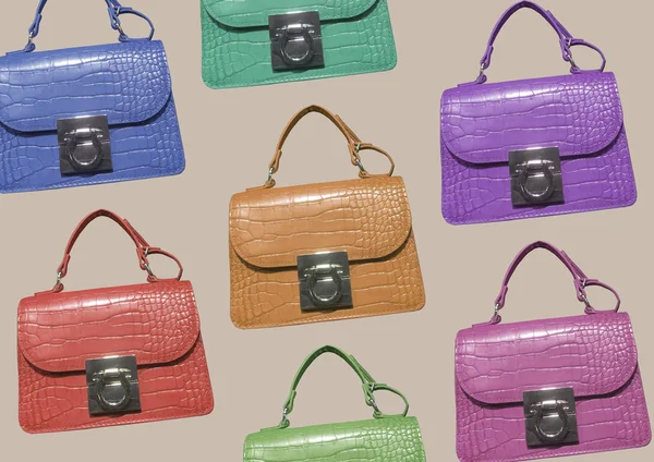 Kahverengi arka planda izole edilmiş çok renkli deri taklit timsah çantaları. Saplı zarif bir kadın çantası. Moda kadın aksesuarları. Moda konsepti. Desen