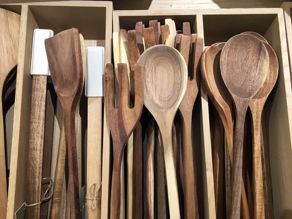 Wooden tongs, spoon, kitchen spatula and  with and spoon for salad in wooden boxes. Kitchen utensils for cooking. Various kitchenware utensils in the decor store