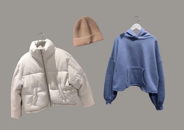 Kışlık kıyafet kolajı kahverengi arka planda izole edilmiş. Moda ceketini indir, kahverengi örgü şapka ve askısında mavi kapüşonlu sweatshirt. Moda kıyafet kolajı. C konsepti. Uzayı kopyala Desen