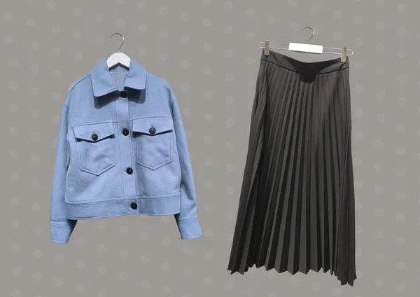 Askıda siyah pileli uzun etek kolajı ve kahverengi arka planda mavi işçi tarzı yün karışımı forma. - Evet. Kıyafet kompozisyonu. Banner konsepti. Moda kıyafet kolajı. Moda.