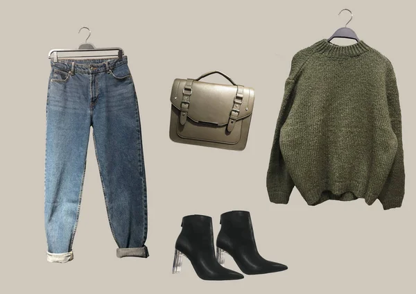 Collage of Cambridge style satchel bag, green oversize knit sweater, black ankle boots pointed toes and methacrylate heels and blue jeans. Composition of clothes. Trendy clothes collage