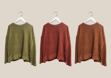 Bej arka planda izole edilmiş askılarda çok renkli örgü süveterler var. Kıyafet kompozisyonu. Banner konsepti. Moda kıyafet kolajı. Moda konsepti. Desen