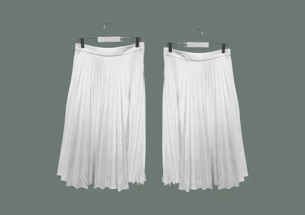 White pleated long skirts isolated on green background pattern. Women\'s Elastic Waist Band Pleated Retro Maxi Long Skirt Dress. Long Accordion Pleated Skirt. Composition of clothes. Flat lay, top view