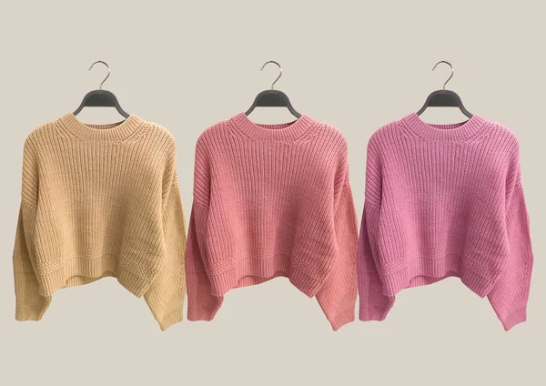 Kahverengi arka planda izole edilmiş askılara çok renkli örgü süveterler. Kıyafet kompozisyonu. Banner konsepti. Moda kıyafet kolajı. Moda konsepti. Desen