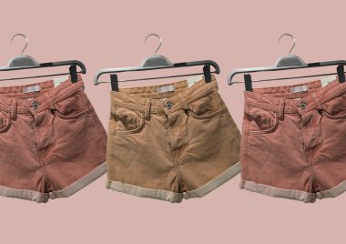 Kahverengi arka planda izole giysiler kolajı. Askıda büyük boy örgü süveter, kot şortlar ve parlak siyah deri Marten çizmeler. Banner konsepti. Moda kıyafet kolajı