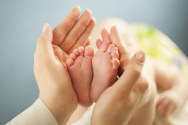 Mãe amor Mãe segurando os pés de seu bebê pequeno, close up.Concept exame de pele por um médico — Fotografia de Stock
