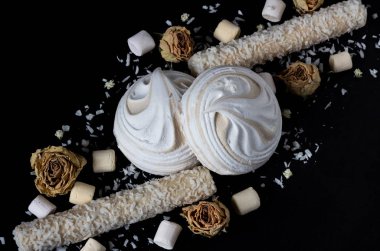 Siyah bir arkaplanda havadaki beyaz şekerlemeler üzerine üst görünüm.