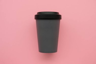 Yeniden kullanılabilir stil çevre dostu pembe arka planda gri bambu bardağı.