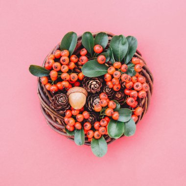 Kırmızı arka planda doğal çevre dostu Noel çelengi.