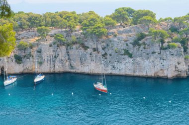 Turkuaz deniz suyu, kayalık kayalıklar ve Calanques Ulusal Parkı 'ndaki tekneler..