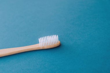 Mavi arka planda ahşap bambu saplı doğal çevre dostu diş fırçası..