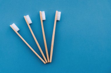 Mavi arka planda ahşap bambu saplı doğal çevre dostu diş fırçaları..