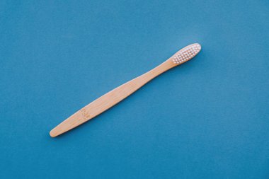 Mavi arka planda ahşap bambu saplı doğal çevre dostu diş fırçası..