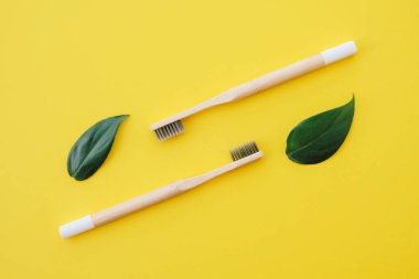 Sarı arka planda çevre dostu doğal bambu diş fırçaları, üst manzara. Ağız temizliği kavramı. Uzayı kopyala Düz yatıyordu. Plastik atıkları azaltmak, sürdürülebilir yaşam tarzı kavramı.