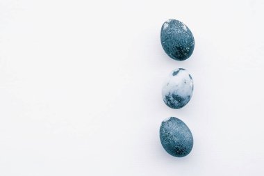 Beyaz arka planda doğal boyalı mavi yumurtalar, üst manzara. Düz yatıyordu. Mutlu Paskalyalar. Boşluğu kopyala.