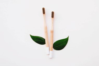 Beyaz arka planda çevre dostu doğal bambu diş fırçaları, üst manzara. Uzayı kopyala Düz yatış stili. Plastik atıkları azaltmak, sürdürülebilir yaşam tarzı kavramı.