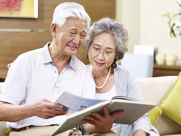 Senior asian couple reading a book together — Stock Photo, Image