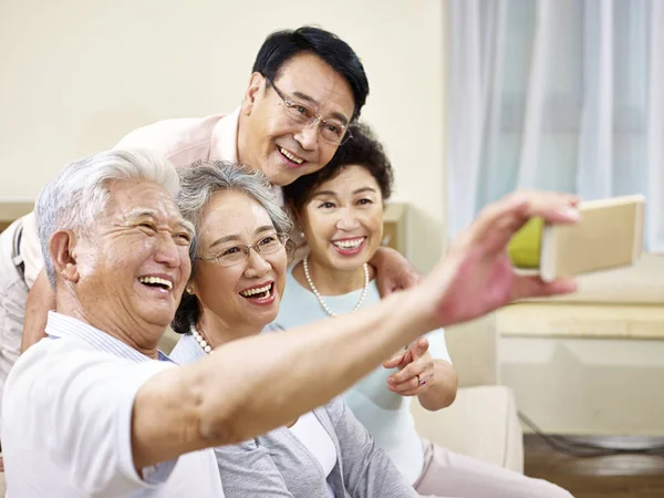 Dois seniores asiático casais tomando um selfie — Fotografia de Stock