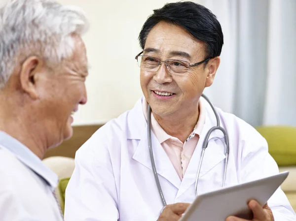Азиатский врач разговаривает с пациентом — стоковое фото