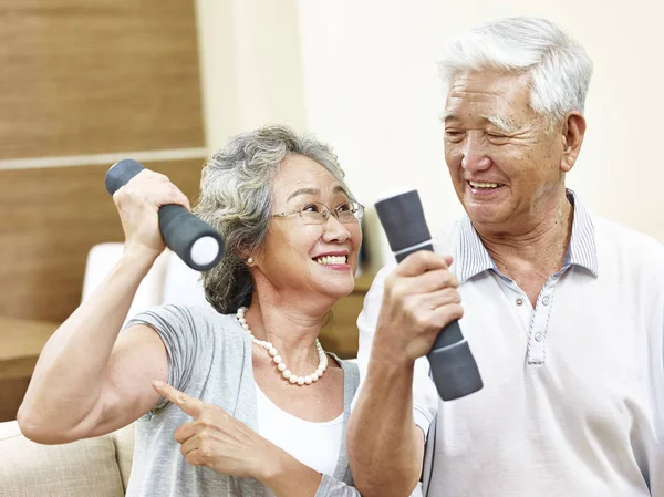 Senior asiático pareja ejercitando usando dumbbells — Foto de Stock