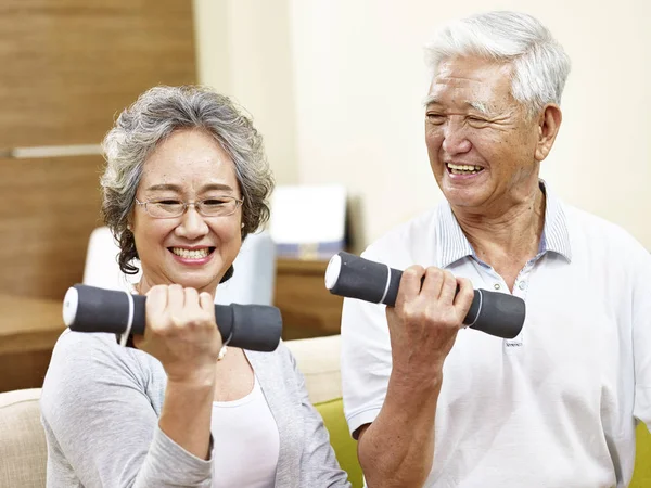 Senior asiático pareja ejercitando usando dumbbells — Foto de Stock