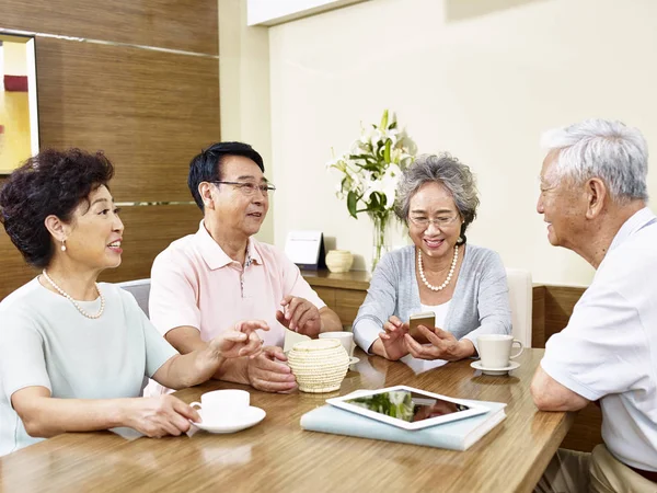 Дві старші азіатські пари спілкуються — стокове фото