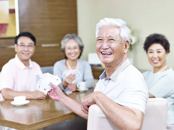 Sênior asiático homem em jogar cartas com amigos — Fotografia de Stock