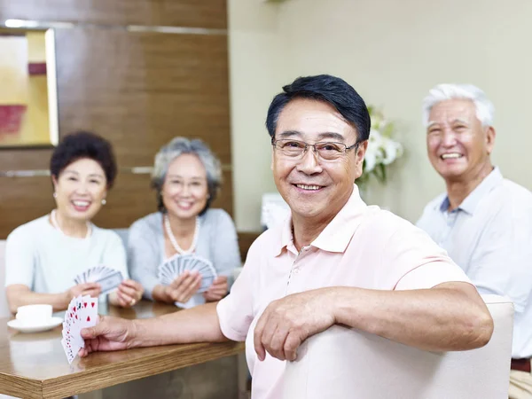 Senior Aziatische man in speelkaarten met vrienden — Stockfoto