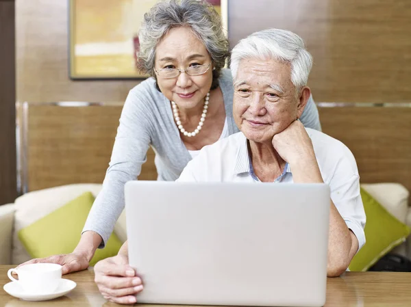 Amando sênior asiático casal usando laptop — Fotografia de Stock